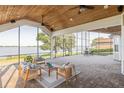 A covered patio with stylish seating, a ceiling fan, and expansive views of the water at 4808 Juliana Reserve Dr, Auburndale, FL 33823