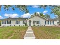 Inviting one-story home with a well-manicured lawn, blue shutters, and a charming front door with decorative glass at 4825 Foxrun, Lakeland, FL 33813