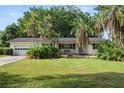 Inviting single-story home with a well-manicured lawn, mature trees, and a cozy bench on the front porch at 509 Rob Roy St, Lakeland, FL 33813
