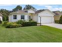 Inviting single-Gathering home featuring an attached two-car garage, lush lawn, and trimmed shrubs at 6250 Silver Leaf Ln, Lakeland, FL 33813