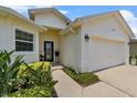Front exterior with meticulous landscape, two-car garage and glass accented front door at 6250 Silver Leaf Ln, Lakeland, FL 33813