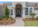 Elegant front entrance with arched doorway, double doors, and lush landscaping at 6527 Eagle Ridge Way, Lakeland, FL 33813
