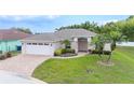 Beautiful single-story home with mature landscaping, a paver driveway, and an attached two-car garage at 7016 Summit Cir, Winter Haven, FL 33884