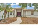 Inviting front entrance with a charming, landscaped yard, covered porch, and secured with an ADT system at 7311 Briarbay Loop, Lakeland, FL 33810