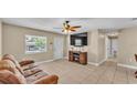 Cozy living room with tile flooring, ceiling fan, and a decorative fireplace at 808 Austin Cir, Bartow, FL 33830