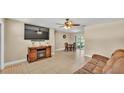 Bright living room with ceiling fan, tile flooring and a view of the dining area at 808 Austin Cir, Bartow, FL 33830