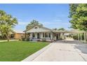 Exterior view of a home with well-manicured lawn, landscaping, and covered parking at 1013 Pennsylvania Ave, Lakeland, FL 33803