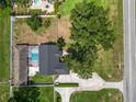 Aerial view of a backyard oasis with a pool, privacy fence, mature trees, well maintained landscaping, and a view of the street at 1130 Ewell Rd, Lakeland, FL 33811