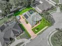 Aerial view of property with pool, screened enclosure, solar panels, brick driveway and lush landscaping at 148 Melissa Trl, Auburndale, FL 33823