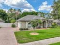 Charming single-story home with lush green lawn, brick driveway and mature landscaping at 148 Melissa Trl, Auburndale, FL 33823