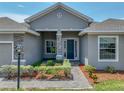 Charming front entrance with well-manicured landscaping and stone column accents at 1547 Cordgrass Way, Lakeland, FL 33813