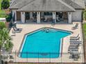 Community pool with many lounge chairs and a shaded structure with chairs and tables at 1547 Cordgrass Way, Lakeland, FL 33813