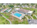 Aerial view of the community pool, clubhouse, tennis courts, and parking area at 1602 Tally Ho Dr, Lakeland, FL 33810