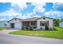 Well-kept home with a landscaped yard, a screened-in porch, and an attached garage on a sunny day at 1608 Colonnades N Cir, Lakeland, FL 33811