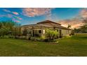Expansive backyard featuring lush greenery, a screened-in pool area, and a covered outdoor living space at 1902 Altavista Cir, Lakeland, FL 33810