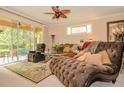 Inviting living room with a plush chaise lounge, sliding glass doors to a patio, and a decorative ceiling fan at 1970 Michael Tiago Cir, Maitland, FL 32751