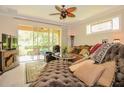 Inviting living room with a plush chaise lounge, sliding glass doors to a patio, and a decorative ceiling fan at 1970 Michael Tiago Cir, Maitland, FL 32751