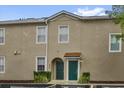 Beige townhouse featuring two front doors, each adorned with planters and greenery at 2061 Crestdale Ln # 60, Lake Mary, FL 32746