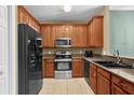 Charming kitchen featuring tile floors, wooden cabinetry, and stainless steel appliances at 2061 Crestdale Ln # 60, Lake Mary, FL 32746