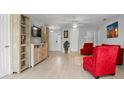 Bright living room with light wood floors, comfortable red chairs, and neutral walls at 2850 Sanderling St, Haines City, FL 33844