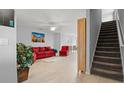 Bright living room features wood-look floors, a ceiling fan, and staircase leading up to the second level at 2850 Sanderling St, Haines City, FL 33844