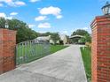 Long driveway leading to a well-maintained home with a horse-themed gate and covered parking at 2921 W Socrum Loop Rd, Lakeland, FL 33810