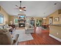 Cozy living room features a brick fireplace, hardwood floors, and comfortable seating arrangement at 2921 W Socrum Loop Rd, Lakeland, FL 33810