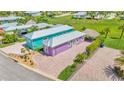 This aerial view shows the home, lush lawn, mature landscaping, and a tiki hut at 3052 Wood Duck Dr, Polk City, FL 33868