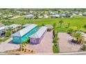This aerial view shows the home, paver driveway, mature landscaping, and a tiki hut at 3052 Wood Duck Dr, Polk City, FL 33868