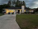 Charming single story home with a spacious front yard and landscaped garden at dusk at 3646 Sherertz Road, Lakeland, FL 33810