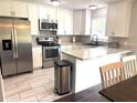 Bright kitchen with stainless steel appliances, white cabinetry, and a breakfast bar at 3646 Sherertz Road, Lakeland, FL 33810