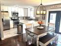 Bright kitchen with stainless steel appliances, white cabinetry, and a cozy dining area at 3646 Sherertz Road, Lakeland, FL 33810