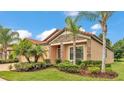 Gorgeous home with lush green landscaping, palm trees, and stone veneer accents at 3934 Aquilla Dr, Lakeland, FL 33810