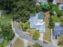 An aerial view showcasing the home's roof, in-ground pool, driveway, and surrounding greenery at 4006 Glen Garry W Rd, Lakeland, FL 33813