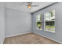 Light-filled bedroom with two windows, neutral walls, and plush carpeting for a comfortable retreat at 4088 Prima Lago Cir, Lakeland, FL 33810