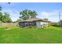 Lush backyard featuring a screened-in porch, wood fence, mature trees and well-maintained lawn at 4219 Sunny Land Dr, Lakeland, FL 33813