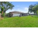 Spacious, lush backyard, featuring a screened in porch, a grill and mature trees for shade at 4219 Sunny Land Dr, Lakeland, FL 33813