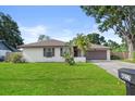 Charming single-story home with a well-manicured lawn, mature landscaping, and mailbox number at 4219 Sunny Land Dr, Lakeland, FL 33813