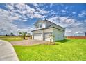 Two-story home with a three-car garage and a meticulously maintained lawn under a partly cloudy sky at 4449 Juliana Lake Dr, Auburndale, FL 33823