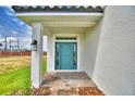 Close-up of a home's front entrance showcasing a striking blue door, brick pavers, and manicured landscaping at 4449 Juliana Lake Dr, Auburndale, FL 33823