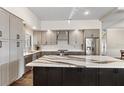 Modern kitchen boasts gray cabinets, stainless steel appliances, and a large center island at 4642 Highlands Place Dr, Lakeland, FL 33813
