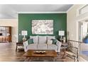 Cozy living room featuring a stylish sofa, dark wood floors, and accent wall at 4642 Highlands Place Dr, Lakeland, FL 33813