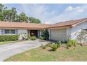 Home featuring a well-kept lawn, mature plantings, and attached two car garage at 5026 N Socrum Loop Rd, Lakeland, FL 33809