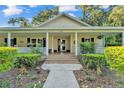 Inviting front porch with brick steps, white columns, and well-maintained landscaping at 5108 Waterwood Dr, Bartow, FL 33830