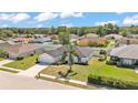 Beautifully landscaped single-Gathering home in a quiet neighborhood with lush green lawn and mature trees at 5458 Oakford Dr, Lakeland, FL 33812