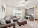 Cozy living room with a large sectional sofa, ottoman, and modern entertainment center at 5768 Anders Way, St Cloud, FL 34771