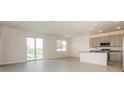 Open-concept living area with sliding glass doors, tile floors, and a modern kitchen area at 606 Fairview Ave # 244, Haines City, FL 33844