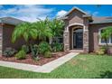 Inviting front entrance with stone pillars, a 'welcome' sign, and lush landscaping at 6339 Alamanda Hills Dr, Lakeland, FL 33813