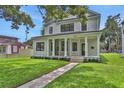 Inviting home with a classic porch, well-maintained lawn, and freshly landscaped garden beds at 731 S Missouri Ave, Lakeland, FL 33815
