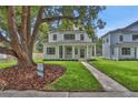Beautiful two-story home featuring a covered porch and lush front yard with mature trees at 731 S Missouri Ave, Lakeland, FL 33815